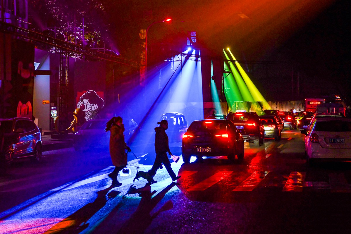 路上的行人和车流，也在光影艺术节的灯光里成为风景的一部分。邹乐摄