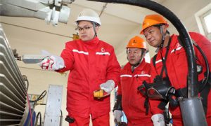 1 图为佘龙（左1）检查6—1计转站电机运行情况。.JPG