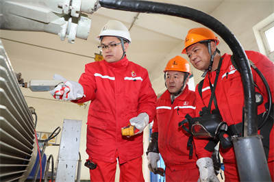 1 图为佘龙（左1）检查6—1计转站电机运行情况。.JPG